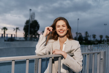 young woman smiling in beige blazer outdoor casual fashion portrait urban background