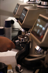 barista rellenando el mango filtro de café con café molido para elaborar un café