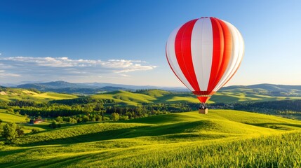 Fototapeta premium Colorful Hot Air Balloon Drifting Above Rolling Green Hills Landscape