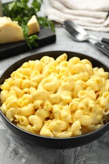 Delicious pasta with cheese sauce in bowl on grey table, closeup