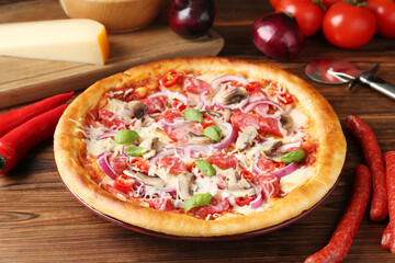 Tasty pizza with smoked sausages and ingredients on wooden table, closeup