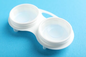 Contact lenses in case on light blue background, closeup