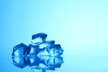 Cubes of clear ice on light blue background, closeup. Space for text