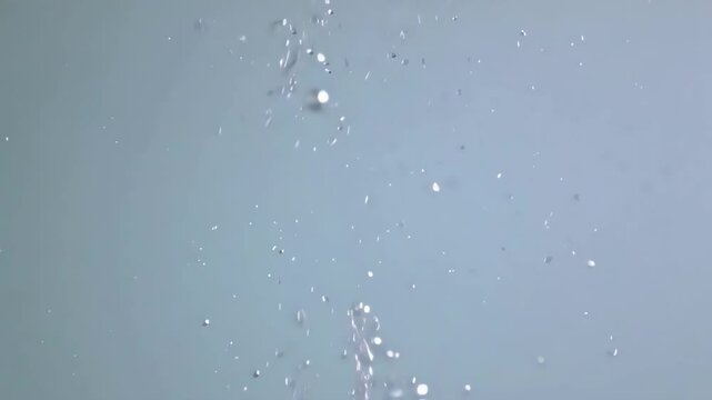Water Splashes against light blue: Capturing the essence of purity, a stunning image features delicate droplets in a dance of freedom. Refreshing, soothing, and evocative.