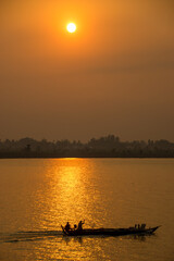 Golden sunset on the Mekong River with a boat in the foreground 