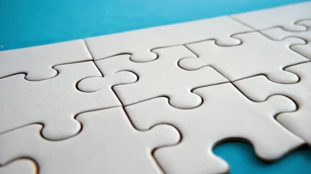 Close up of a white jigsaw puzzle with a missing piece revealing a blue background underneath it