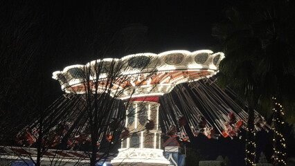 Carousel Night Ride Amusement Park: Illuminated swinging carousel ride at night, providing...