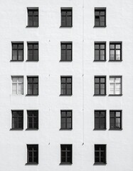古い白塗り住宅のファサードと規則的な窓のリズム

