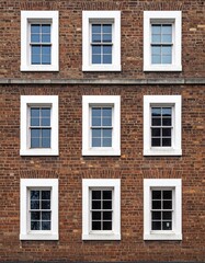 Fototapeta premium 古レンガ壁のテクスチャと白枠の正方形窓が織りなす美しい規則性のディテール。