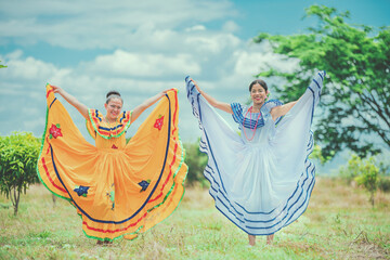Portrait of smiling girls in national folk costume in a field. Women wearing traditional Nicaraguan...