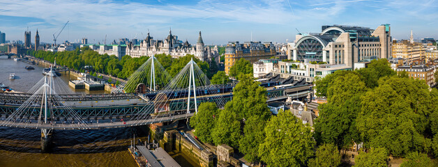 Aerial view of London Charing Cross railway station with its arched glass facade, train platforms, and surrounding city buildings