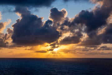 Sunset Over the Ocean with Dramatic Clouds and Golden Sunlight