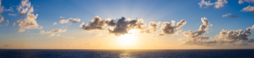 Scenic Sunset Over Ocean with Clouds and Bright Horizon