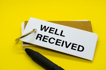 Well Received Text on white notepad with yellow cover background