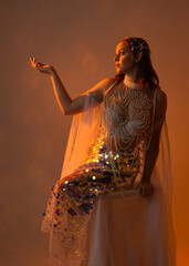 Fantasy studio portrait of a red-haired mermaid faery model wearing white pearl gown, fairytale...
