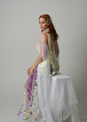 Fantasy studio portrait of a red-haired mermaid faery model wearing white pearl gown, fairytale...