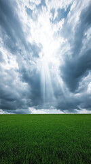 Sunbeams breaking through storm clouds over green field