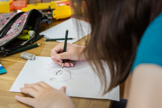 Naklejki Young teenage girl creating artwork, drawing Manga and stencilling at the table