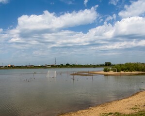 a football field flooded with flood water during the spring flood of the river on a sunny spring day
