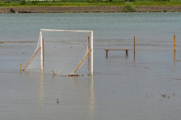 spring flood on the Kuban River - football goal flooded with rising water on a sunny spring day