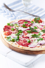 Pizza with salami and mozzarella cheese. Wooden background. Soft focus. Close up.