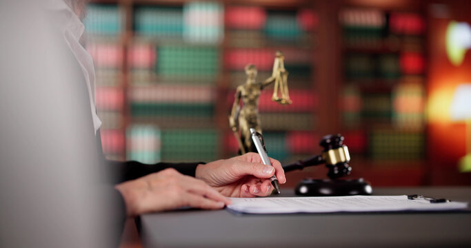 Professional Lawyer Signing Legal Document In Courthouse