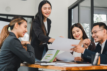 Business team meeting with data analysis documents, young professionals discussing project strategy in modern office, teamwork and collaboration create positive atmosphere for success