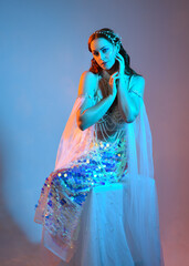 Fantasy studio portrait of a red-haired mermaid faery model wearing white pearl gown, fairytale...