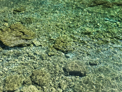 Pebbles and stones in sea transparent water 