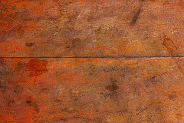 Close-up of a reddish-brown textured surface with horizontal joint line, likely aged wood, highlighting texture or background.


