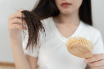 Asian woman very shock looking at damaged hair, hair loss, hair thinning problem, vitamin...