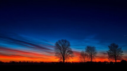Fototapeta premium Breathtaking Sunset with Vibrant Sky Colors and Silhouetted Trees Against a Beautiful Horizon