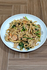 Fried noodles with vegetables and shrimp, looks very delicious served on a plate.