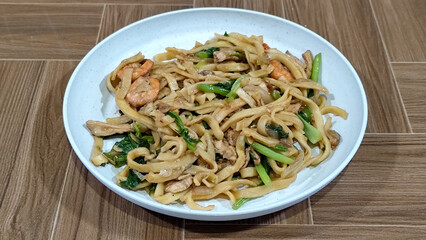 Fried noodles with vegetables and shrimp, looks very delicious served on a plate.