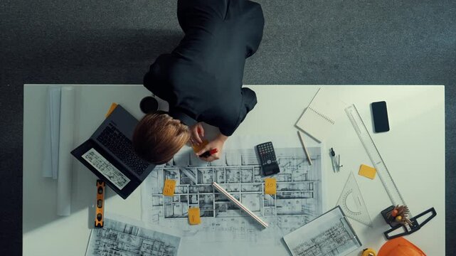 Time lapse of skilled project manager holding project plan and explain house design to architect engineer at meeting table with equipment, ruler, safety helmet and laptop scatter around. Alimentation.