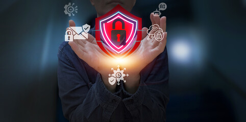 Cybersecurity professional holds a glowing digital shield with a padlock symbol, surrounded by security icons, representing data protection and network safety.