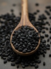 A wooden spoon filled with black sesame seeds.