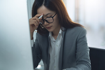 Asian business woman stressed while working on computer at office, Tired businesswomen with headaches, feel sick depressed at work, stress for contract mistake, policy fail and burnout