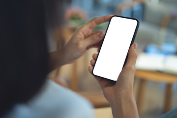 Mockup blank white screen mobile phone. Woman hand holding, using smartphone at coffee shop, template for mobile app design, social media marketing, close up