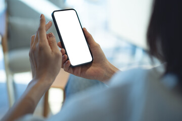 Mockup blank white screen mobile phone. Woman hand holding, using smartphone at coffee shop, template for mobile app design, social media marketing, close up