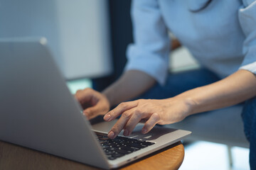 Closeup, business woman working on laptop computer wooden table at coffee shop. Woman freelancer connecting the internet, online working at cafe, freelance at work, online job