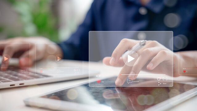 Hands using digital tablet and laptop to play video content on streaming platform. Concept of online media, content marketing, social network, video sharing, and digital communication.