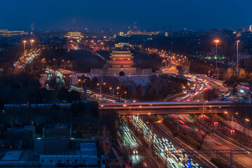 Yongdingmen City Tower at night in Beijing, China, with vehicle flow, traffic, and urban nightlife