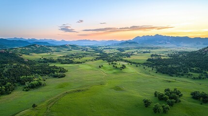 Fototapeta premium Tranquil sunrise over vast green meadows remote landscape aerial view nature serenity