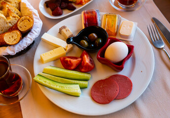 Halal breakfast at the hotel of boiled eggs, smoked sausage, chopped vegetables, cheese, olives,...