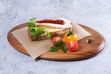 Delicious open-faced sandwich with fresh vegetables served on wooden platter