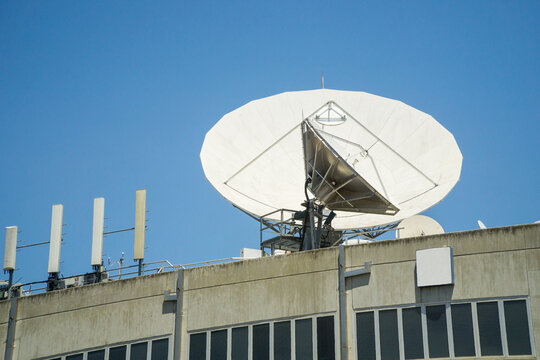 Large telecommunications dishes on rooftop of a building