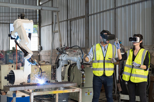 Robotic arm, Automatic robotic arm welding. Team of engineers install, maintain, repair mechanism of operation of robotic arm welding in robotic storage warehouse