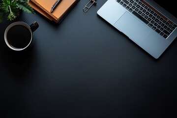 Minimalist workspace with a laptop, black coffee cup, orange notebook, pen, and green plant on a dark textured surface conveying focus and productivity