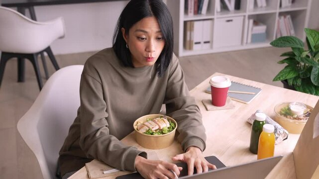 Woman eating healthy meal while working, Businesswoman having a lunch break at the office